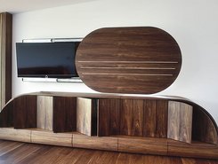 dunkle Wohnwand aus Holz mit Elementen für TV